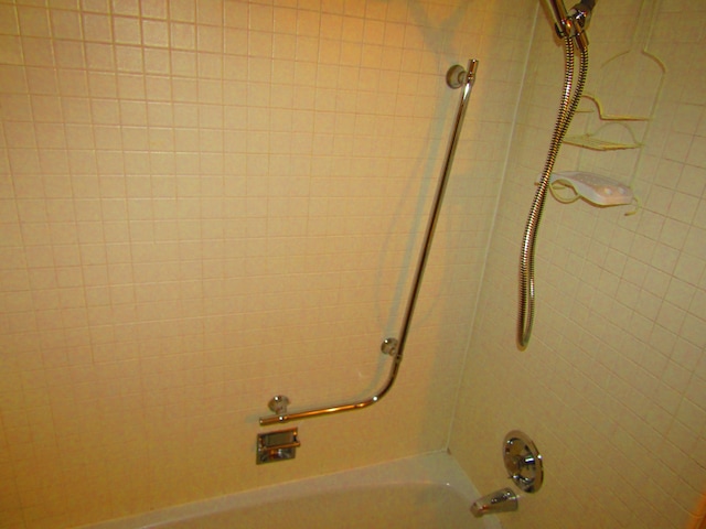 details with tiled shower / bath combo