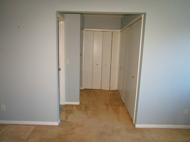 hallway featuring light colored carpet