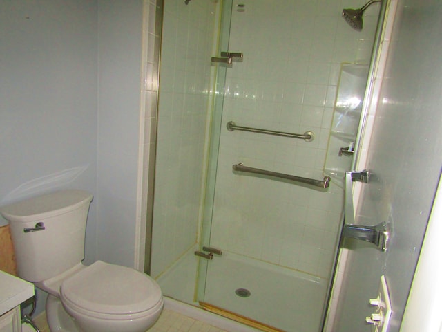 bathroom with vanity, a shower with door, and toilet