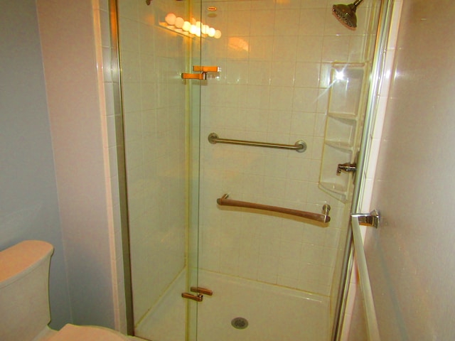 bathroom featuring an enclosed shower and toilet