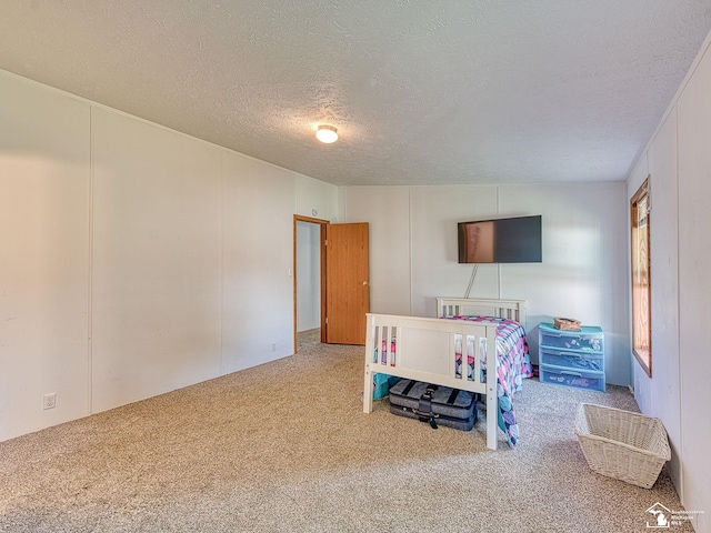 bedroom with carpet floors and a textured ceiling