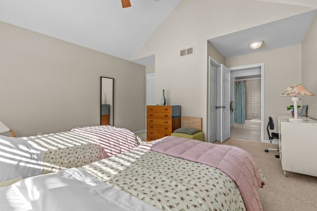 bedroom with connected bathroom, high vaulted ceiling, light colored carpet, and ceiling fan