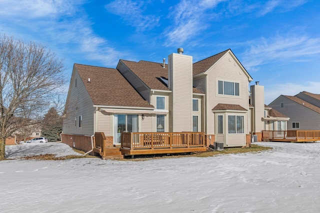 snow covered house featuring a deck