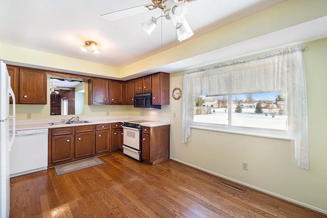 kitchen with ceiling fan, dark hardwood / wood-style floors, sink, and white appliances