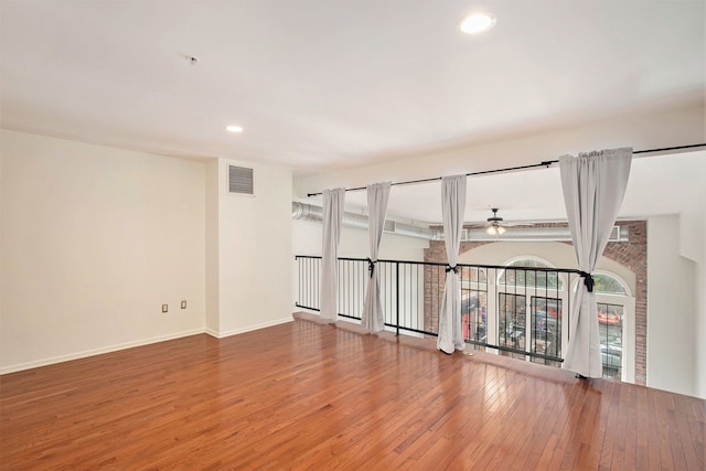 empty room with hardwood / wood-style flooring and ceiling fan