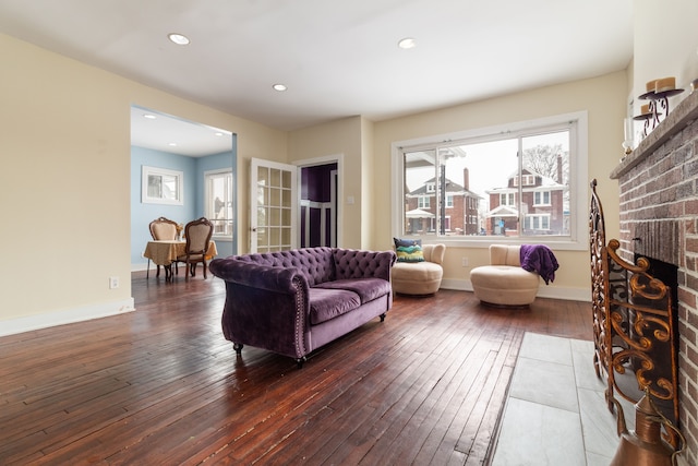 living room with dark hardwood / wood-style floors and a fireplace