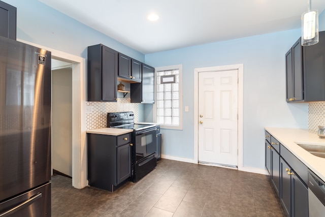 kitchen with pendant lighting, appliances with stainless steel finishes, sink, and backsplash