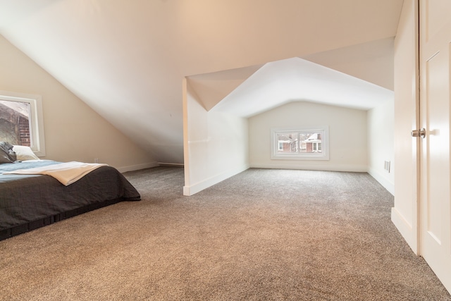 carpeted bedroom with lofted ceiling