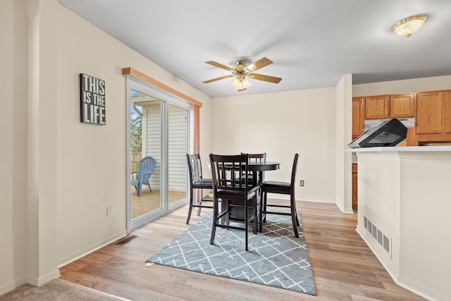 dining area with ceiling fan and light hardwood / wood-style floors