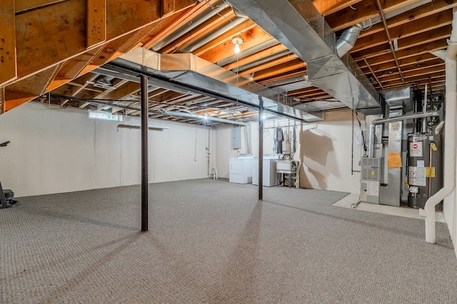 basement featuring washing machine and clothes dryer, a wealth of natural light, heating unit, and gas water heater