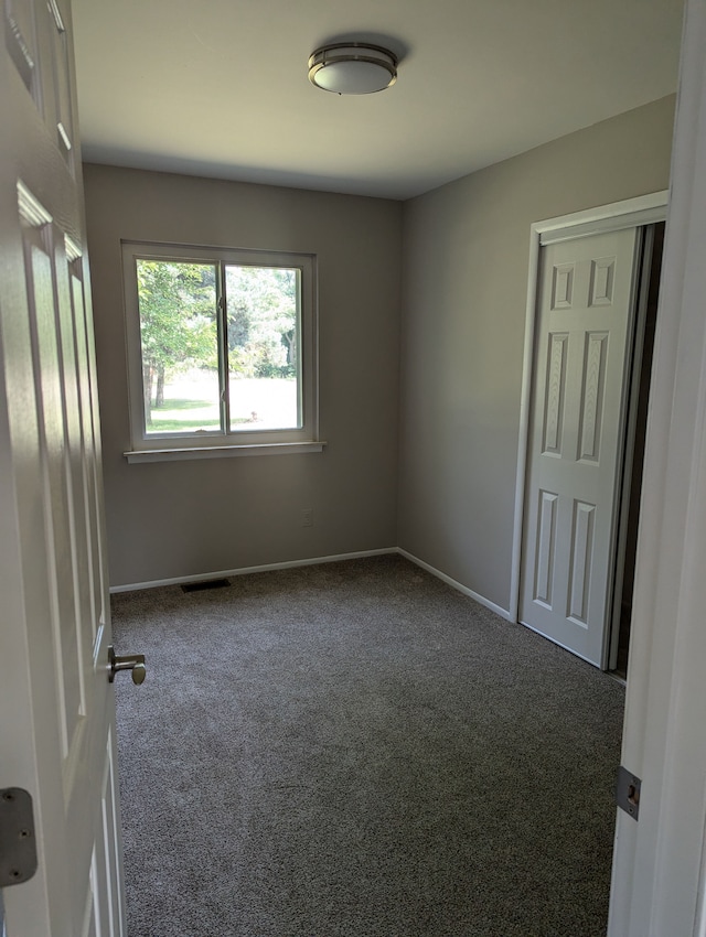 empty room featuring dark carpet