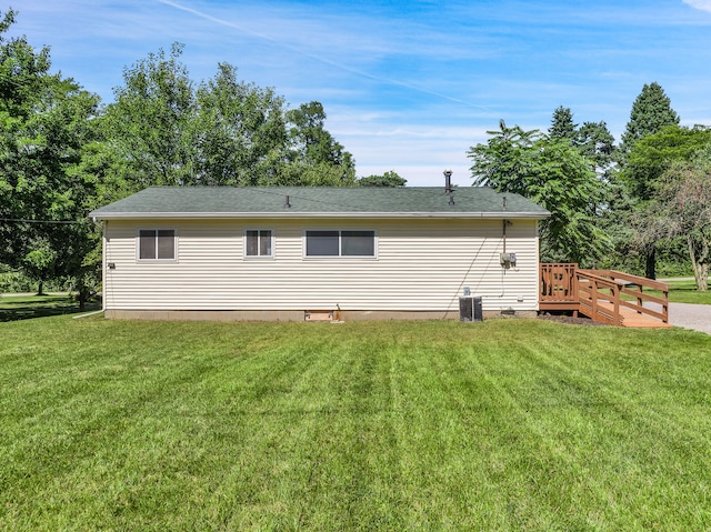 rear view of property featuring a wooden deck, a yard, and central AC unit