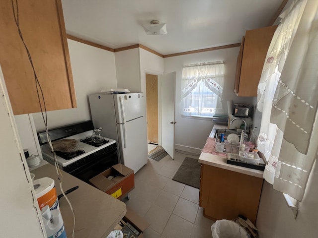 kitchen featuring light tile patterned flooring, sink, range with gas cooktop, crown molding, and white fridge