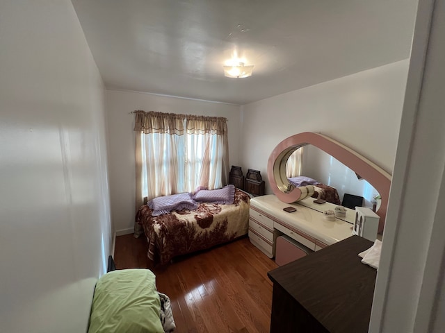 bedroom with dark hardwood / wood-style flooring