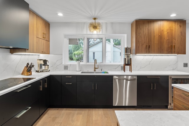 kitchen with pendant lighting, sink, light hardwood / wood-style flooring, dishwasher, and tasteful backsplash