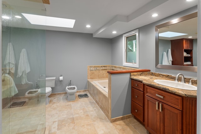 bathroom with toilet, a skylight, a bidet, vanity, and a relaxing tiled tub