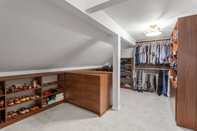 walk in closet featuring light carpet and lofted ceiling