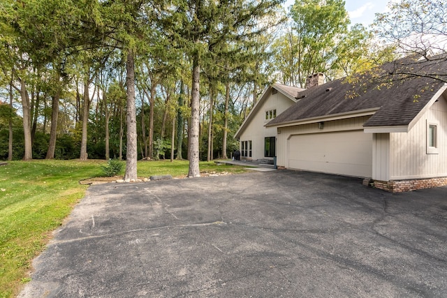 view of side of property with a garage and a lawn