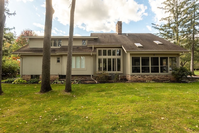 back of property featuring a yard and a sunroom