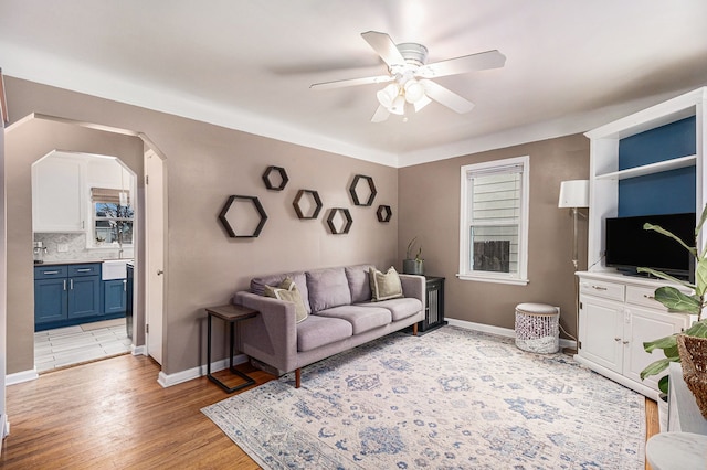 living room with ceiling fan and light hardwood / wood-style floors