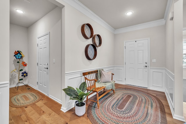 foyer entrance with crown molding and light wood-type flooring