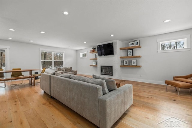 living room featuring plenty of natural light, a fireplace, and light hardwood / wood-style floors