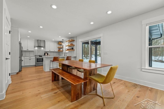 dining area featuring a wealth of natural light, sink, and light wood-type flooring