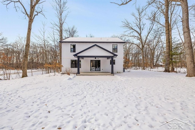 snow covered property featuring covered porch