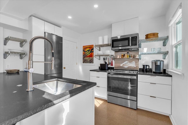 kitchen featuring stainless steel appliances, white cabinetry, and sink