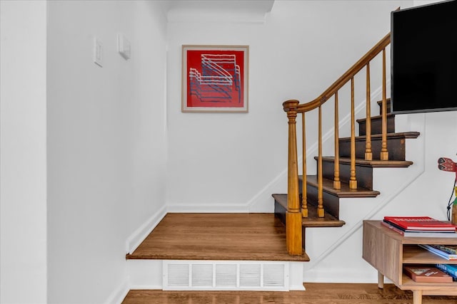 staircase with hardwood / wood-style floors