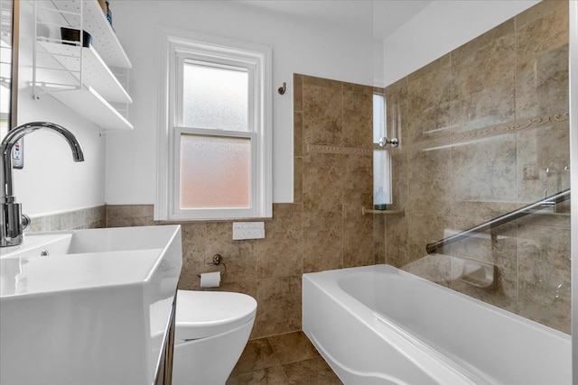 bathroom featuring sink, tile walls, a bath, tile patterned floors, and toilet