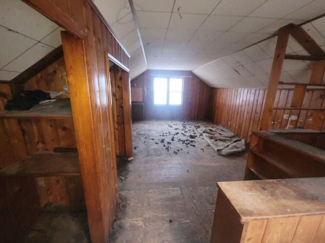 additional living space featuring lofted ceiling and wood walls