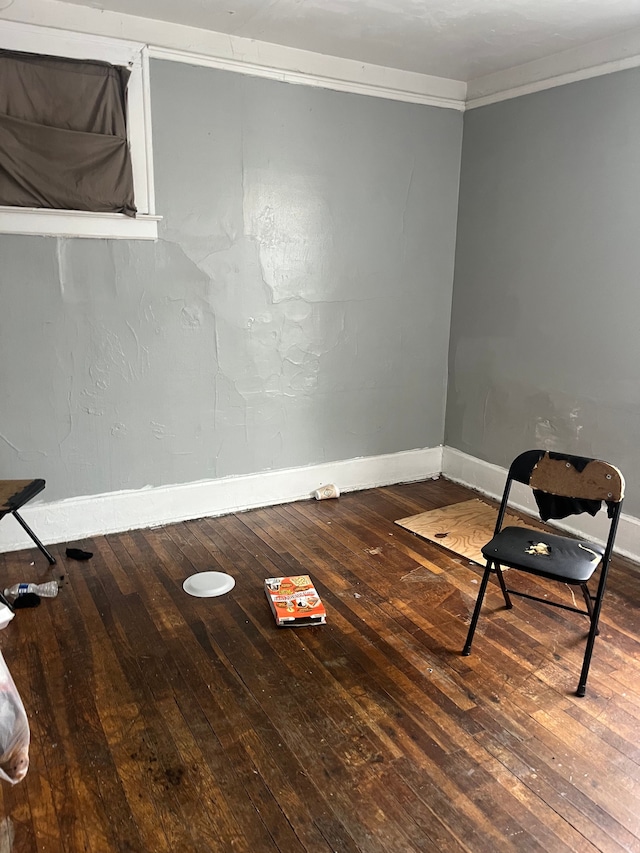 spare room with crown molding and wood-type flooring