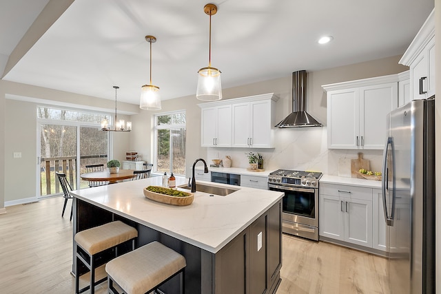 kitchen featuring white cabinetry, appliances with stainless steel finishes, and wall chimney range hood