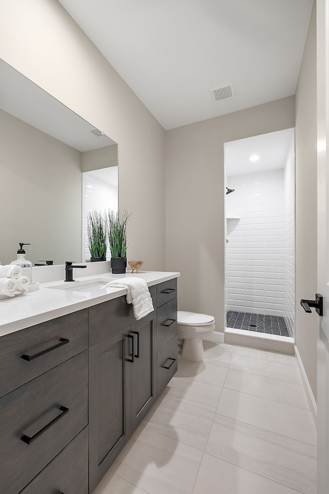 bathroom with tile patterned flooring, vanity, walk in shower, and toilet