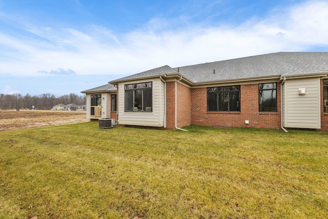 back of property with cooling unit and a yard