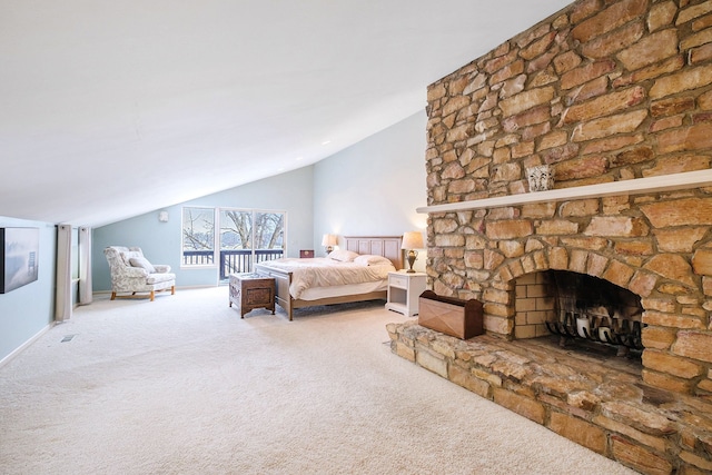 carpeted bedroom featuring a stone fireplace and vaulted ceiling