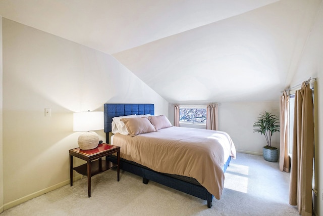 bedroom with light colored carpet and vaulted ceiling