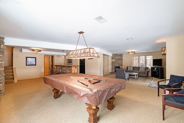 game room with a stone fireplace, light carpet, and pool table