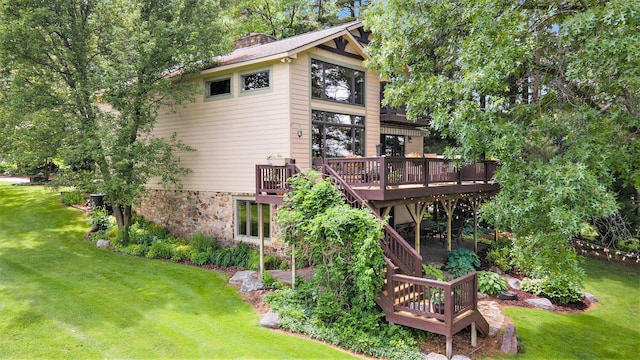 back of house with a wooden deck and a yard