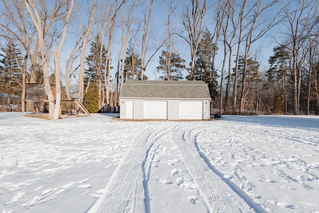 yard covered in snow featuring a garage and an outdoor structure