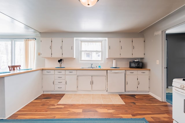 kitchen with sink, white cabinets, decorative backsplash, light hardwood / wood-style floors, and white appliances