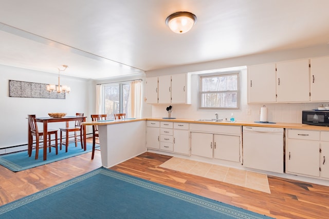 kitchen with white dishwasher, decorative light fixtures, light hardwood / wood-style flooring, and white cabinets