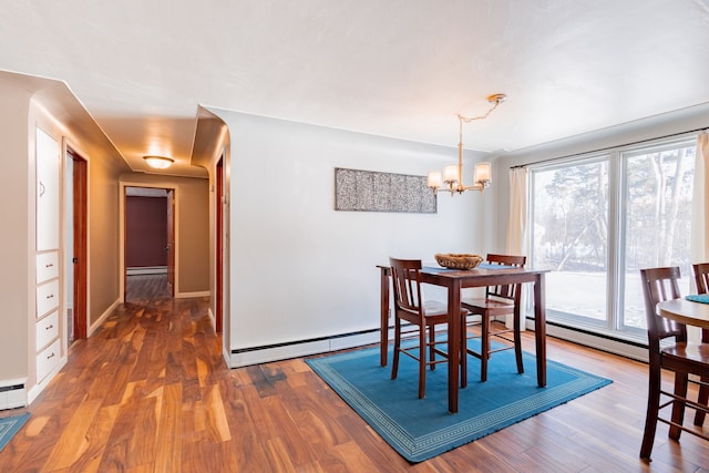 dining room featuring baseboard heating, dark hardwood / wood-style floors, and a wealth of natural light