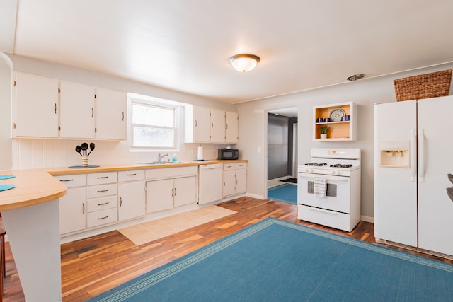 kitchen featuring wood-type flooring, backsplash, white cabinets, and white appliances