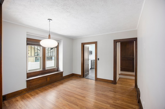 spare room featuring crown molding, wood-type flooring, and a textured ceiling