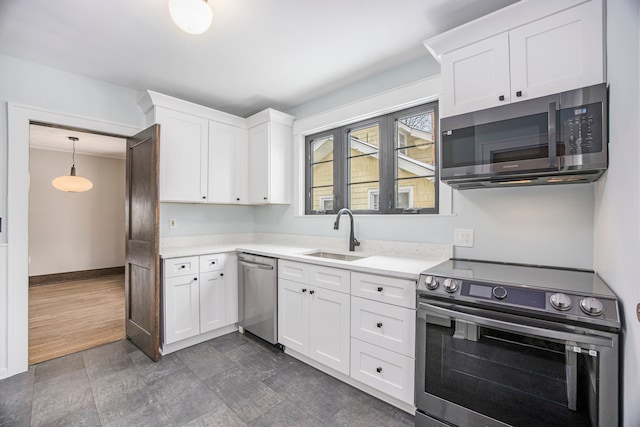 kitchen featuring appliances with stainless steel finishes, sink, pendant lighting, and white cabinets