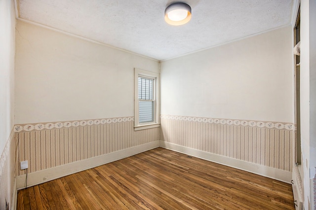 unfurnished room featuring hardwood / wood-style flooring and a textured ceiling