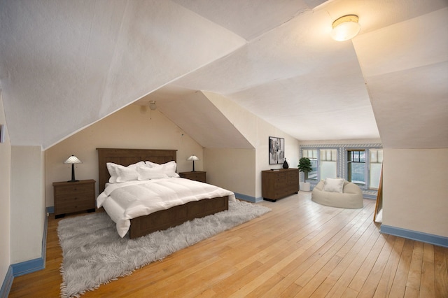 bedroom featuring hardwood / wood-style flooring and vaulted ceiling