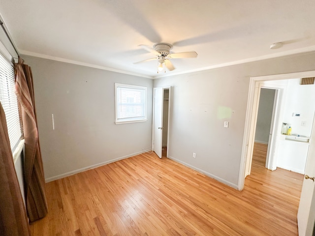 unfurnished bedroom featuring light hardwood / wood-style flooring, ornamental molding, and ceiling fan